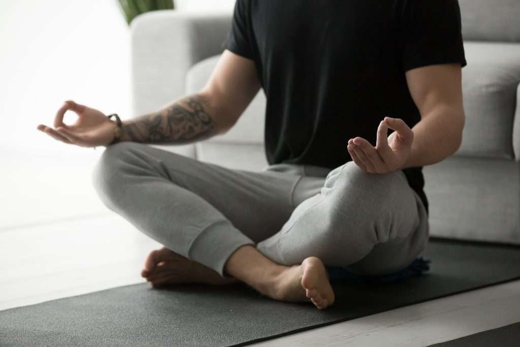 Man meditating on a yoga mat